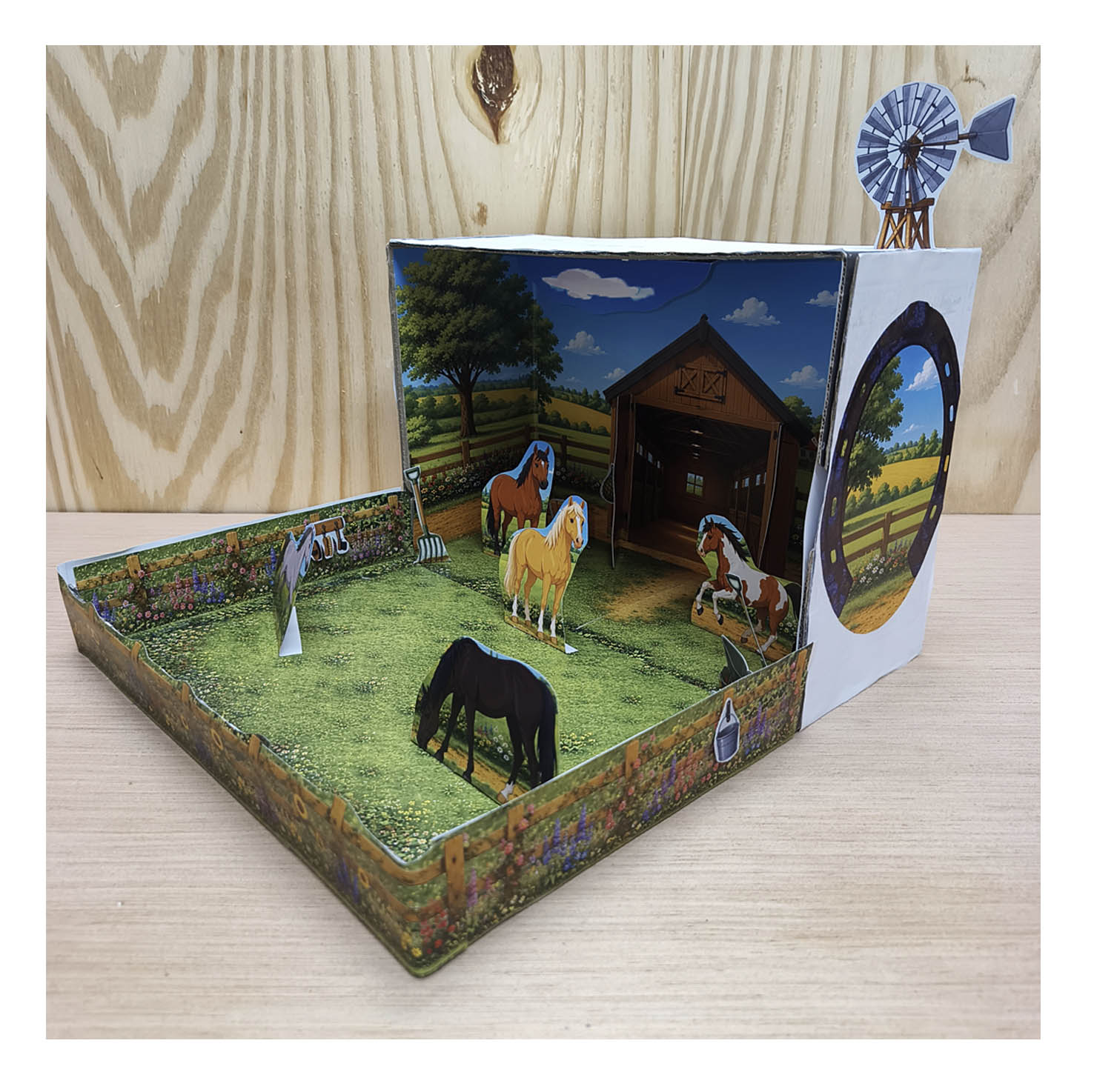 Angled view of the finished printable horse stable and paddock craft showing the layered 3D shoebox construction