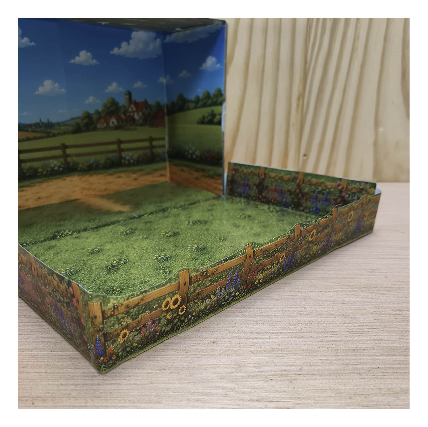 Close view of the printable paddock edge with wooden horse fence, green plants and colorful flowers inside the shoebox diorama